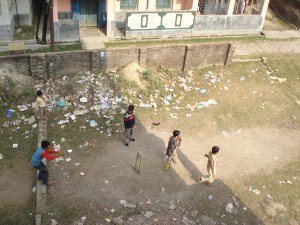 Malda - boys playing cricket among the rubbish